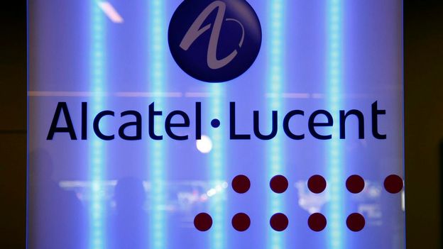 Logo Alcatel-Lucent illuminé sur fond bleu, avec des lumières verticales en arrière-plan
