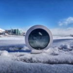 Round Xiaomi Bluetooth thermometer showing an E1 error, half-buried in snow with Chicago's Navy Pier Ferris wheel visible in the background