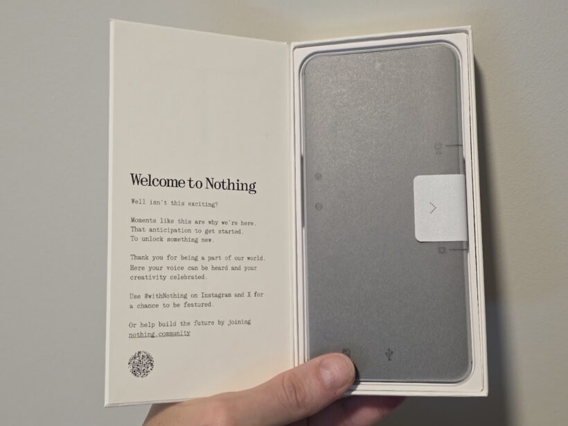 Nothing Phone box opened, showing the device inside and a welcome card reading "Welcome to Nothing" with a note to join nothing.community
