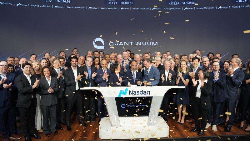 Quantinuum team celebrating at the Nasdaq MarketSite during the company's IPO opening bell ceremony, with gold confetti falling