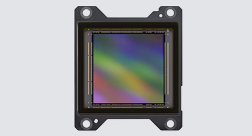 Sony IMX928 image sensor showing its square 1:1 silicon die with iridescent surface in a black mounting frame