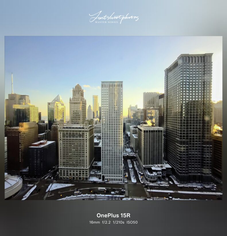 OnePlus 15R ultrawide camera sample: Chicago skyline shot at 16mm f/2.2, snow-dusted streets between downtown skyscrapers at golden hour