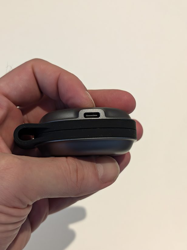 Hand holding the folded UGREEN MagFlow 2-in-1, showing its USB-C port sitting slightly proud of the body