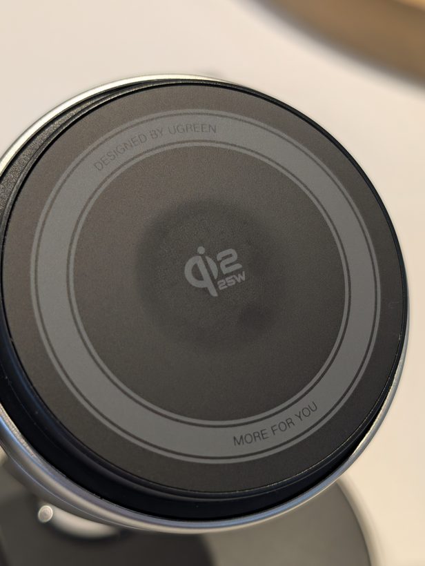 Close-up of the UGREEN 3-in-1 charging stand's circular Qi2 25W magnetic pad, engraved with "Designed by UGREEN" and "More For You