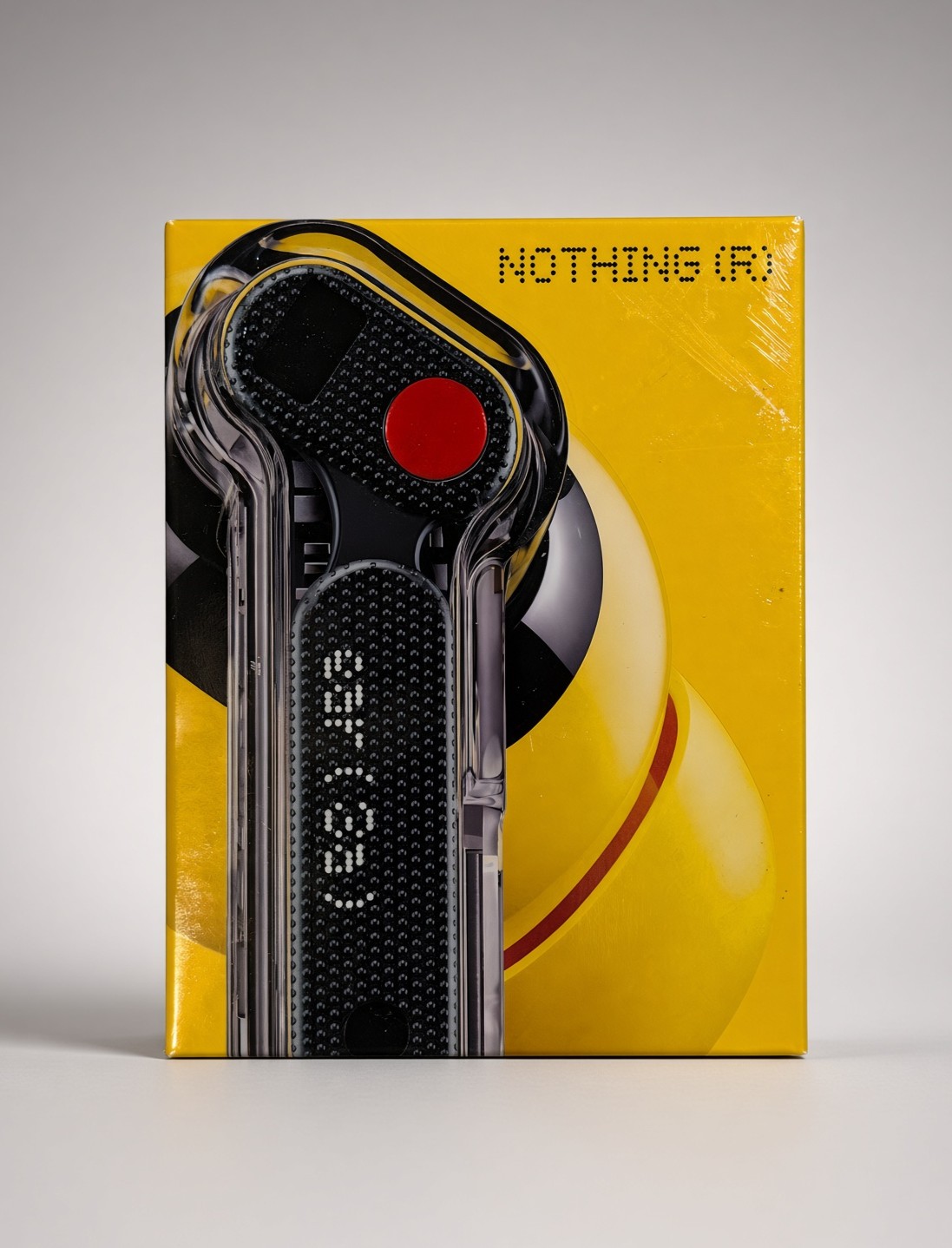 Yellow retail box labeled Nothing (R), featuring a graphic of a transparent black remote-style device with a red button